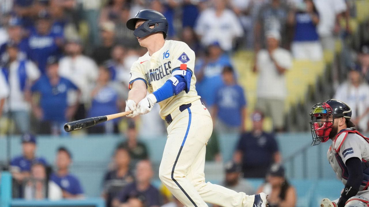 Los Angeles Dodgers' Will Smith, left, drives in the winning run with a single during the 11th inning of a baseball game against the Boston Red Sox, Saturday, July 20, 2024, in Los Angeles. (AP Photo/Marcio Jose Sanchez)