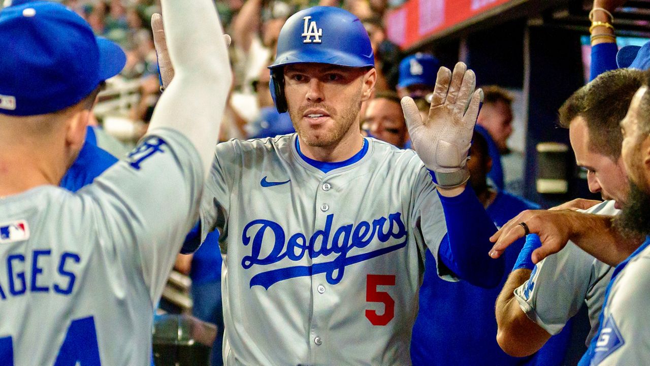 Los Angeles Dodgers' Freddie Freeman celebrates in the dugout after hitting three-run home run in the seventh inning of a baseball game against the Atlanta Braves, Monday, Sept. 16, 2024, in Atlanta. (AP Photo/Jason Allen)