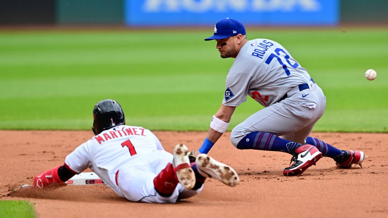 Cleveland Guardians' Angel Martinez slides safely into second base for a double as Los Angeles Dodgers second baseman Miguel Rojas misplays the baseball during the first inning of a baseball game, Wednesday, May 28, 2025, in Cleveland. (AP Photo/David Dermer)