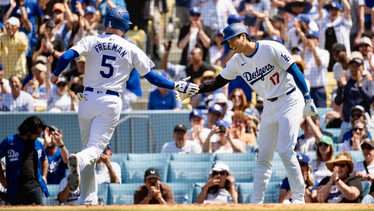 Los Angeles Dodgers' Shohei Ohtani (17) celebrates with Freddie Freeman (5) after they score on a two-run double by Will Smith during the fifth inning of a baseball game against the New York Mets in Los Angeles, Sunday, April 21, 2024. (AP Photo/Kyusung Gong)