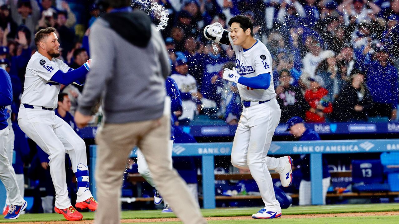 Los Angeles Dodgers' Shohei Ohtani, right, is congratulated by Miguel Rojas after a walk-off home run against the Atlanta Braves during the ninth inning of a baseball game Wednesday, April 2, 2025, in Los Angeles. (AP Photo/Kevork Djansezian)