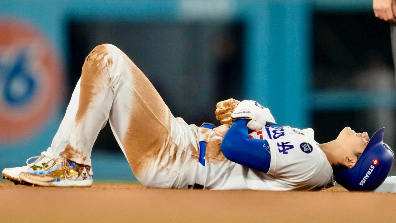 Los Angeles Dodgers' Shohei Ohtani is hurt after sliding into second base during the seventh inning in Game 2 of the baseball World Series against the New York Yankees, Saturday, Oct. 26, 2024, in Los Angeles. (AP Photo/Ashley Landis)