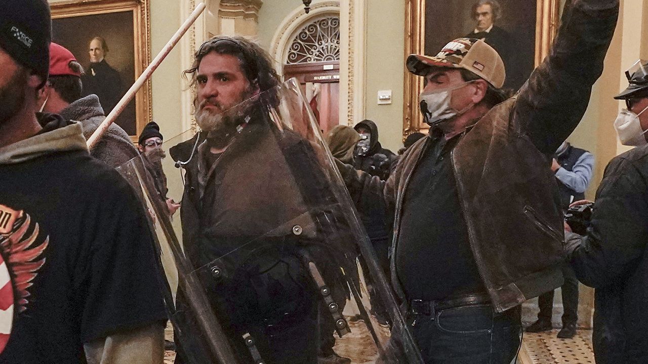 Rioters, including Dominic Pezzola, center with police shield, are confronted by U.S. Capitol Police officers outside the Senate Chamber inside the Capitol, Wednesday, Jan. 6, 2021, in Washington.  (AP Photo/Manuel Balce Ceneta, File)