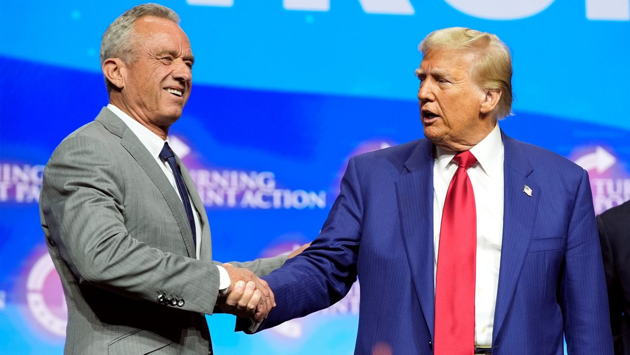 Republican presidential nominee former President Donald Trump shakes hands with Robert F. Kennedy Jr., at a Turning Point Action campaign rally, Wednesday, Oct. 23, 2024, in Duluth, Ga. (AP Photo/Alex Brandon)