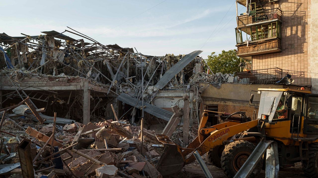 A tractor clears the rubble after a Russian strike on the Sapphire hotel in Kramatorsk, Donetsk region, Ukraine, on Sunday, Aug. 25, 2024. (AP Photo/Evgeniy Maloletka)