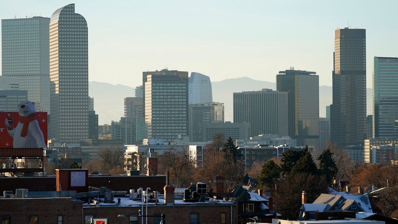 The skyline is backlighted as the sun sets late Sunday, Dec. 13, 2020, in Denver. (AP Photo/David Zalubowski)