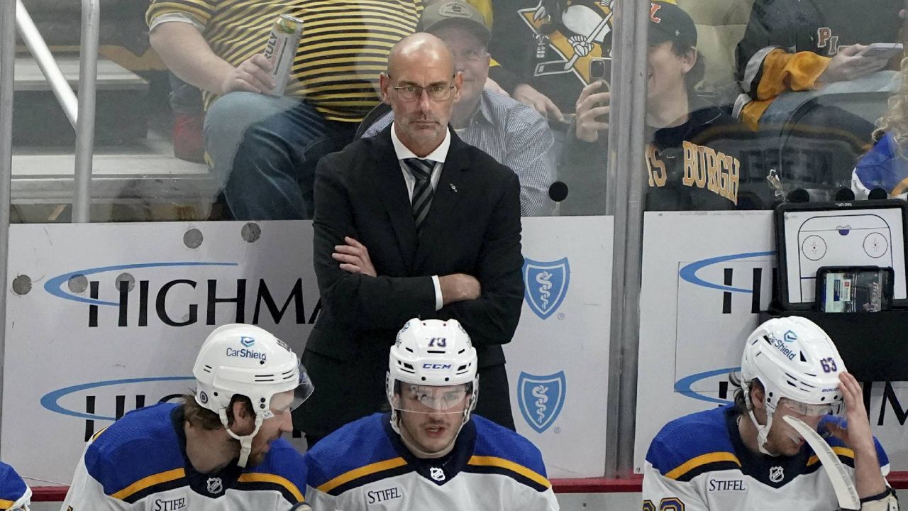 St. Louis Blues interim head coach Drew Bannister, center top, stands behind the bench during the first period of an NHL hockey game against the Pittsburgh Penguins, Saturday, Dec. 30, 2023, in Pittsburgh. (AP Photo/Matt Freed)