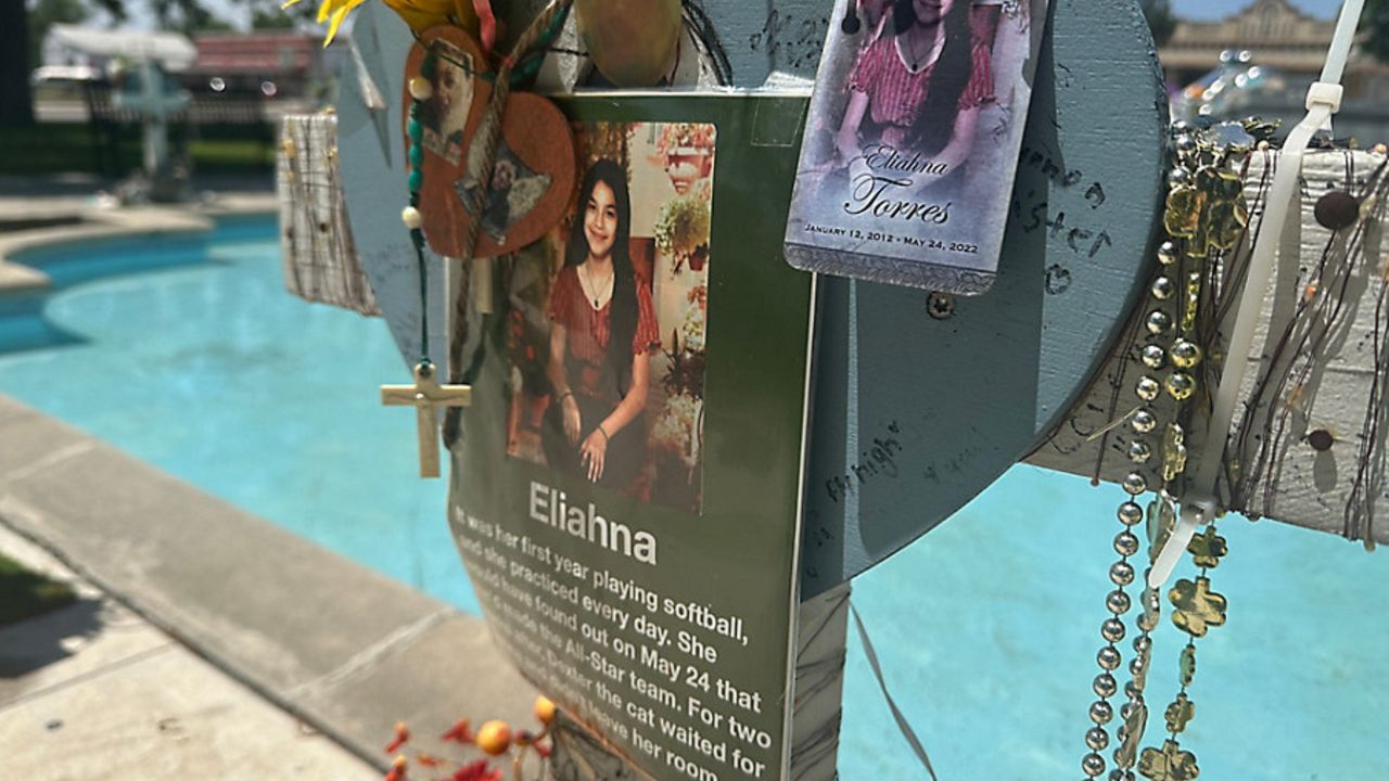 A cross honoring victim Eliahana Torres sits at the plaza in downtown Uvalde (Spectrum News 1/Bryan Boes)