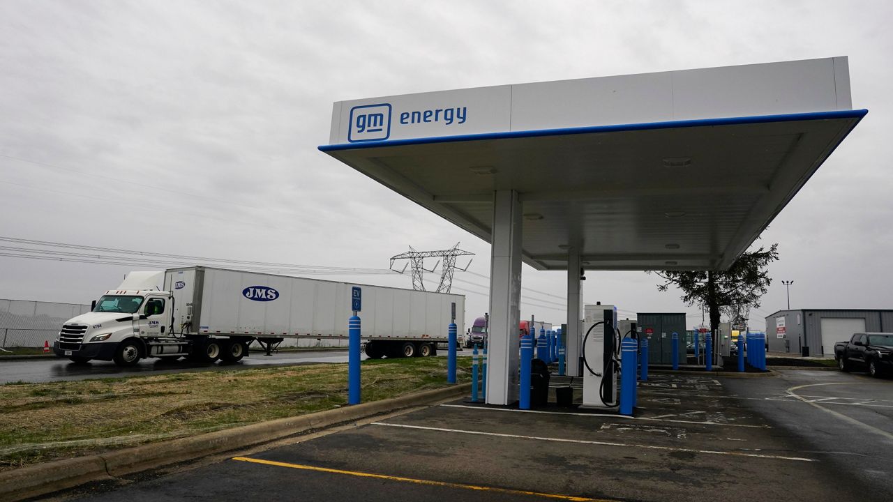 A truck drives by an electric vehicle charging station, Friday, March 8, 2024, in London, Ohio. The charging ports are a key part of President Joe Biden’s effort to encourage drivers to move away from gasoline-powered cars and trucks that contribute to global warming. (AP Photo/Joshua A. Bickel)