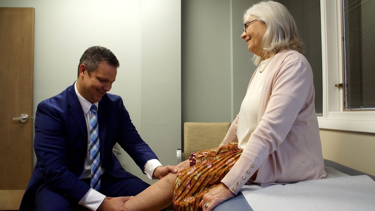 Orthopedic Surgeon John Dundon monitors patient Dr. Barbara Girz' recovery after her knee replacement.