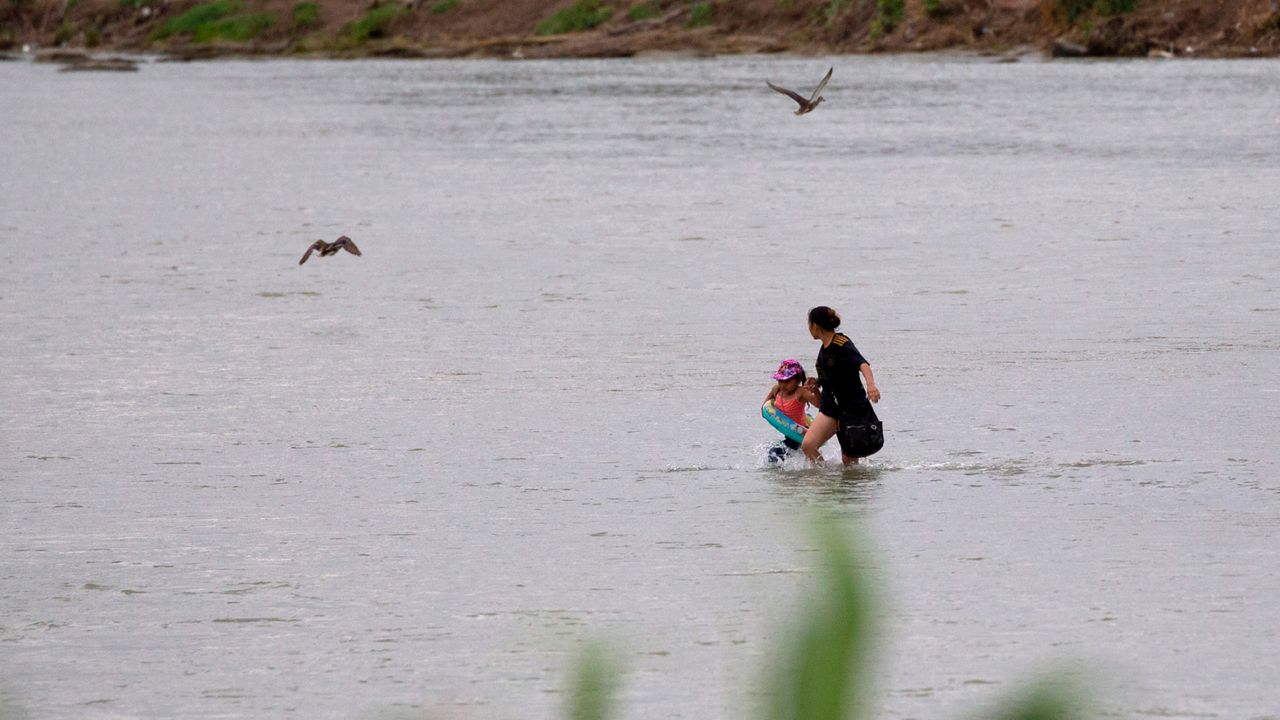 A woman and a child cross the Rio Grande river towards the U.S. in Eagle Pass, Texas, Sunday May 22, 2022. (AP Photo/Dario Lopez-Mills)