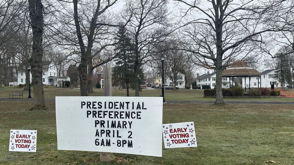 Signs dot the town green in Colchester, Conn., on Wednesday, March 27, 2024, reminding voters they can vote early in the state's presidential primary. It marks the first time voters can vote early and in-person in Connecticut. (AP Photo/Susan Haigh)