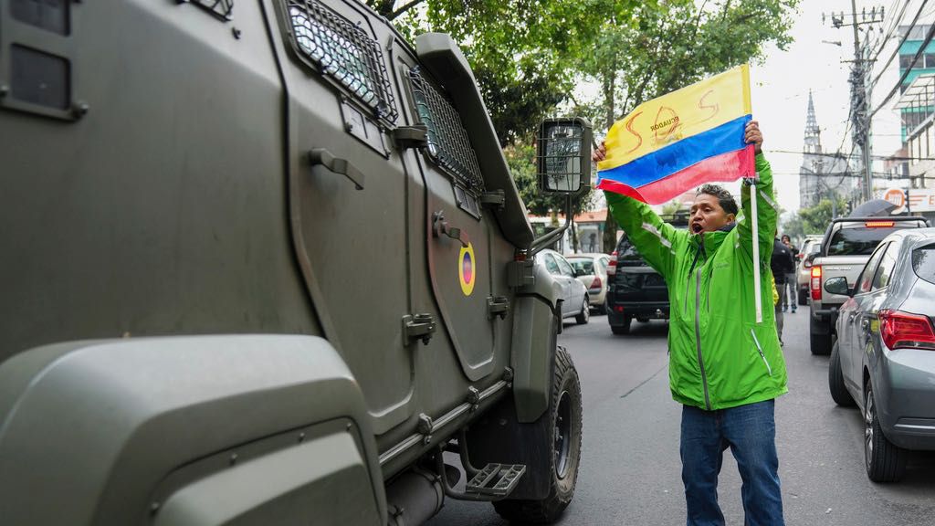 A supporter of former Ecuadorian Vice President Jorge Glas protests as a military vehicle transports him from the detention center he was held following his arrest at the Mexican Embassy in Quito Ecuador, Saturday, April 6, 2024. (AP Photo/Dolores Ochoa)