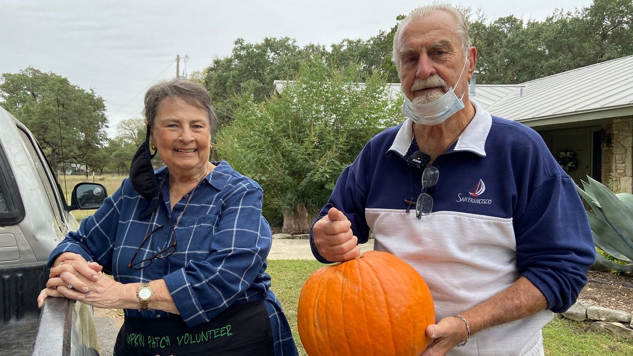 Connie and Ed Bremer pose with a pumpkin (Lauren Due/Spectrum News)