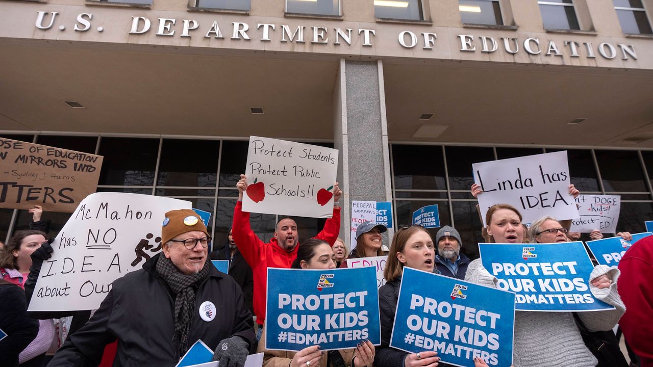 Protesters gather during a demonstration at the headquarters of the Department of Education, Friday, March 14, 2025, in Washington. (AP Photo/Mark Schiefelbein)