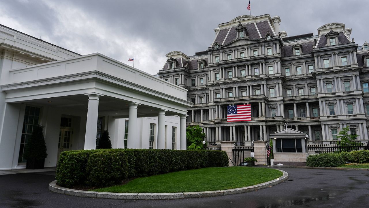 An America 250 flag is seen on the Eisenhower Executive Office Building, past the West Wing of the White House, Sunday, April 19, 2026, in Washington. (AP Photo/Julia Demaree Nikhinson)
