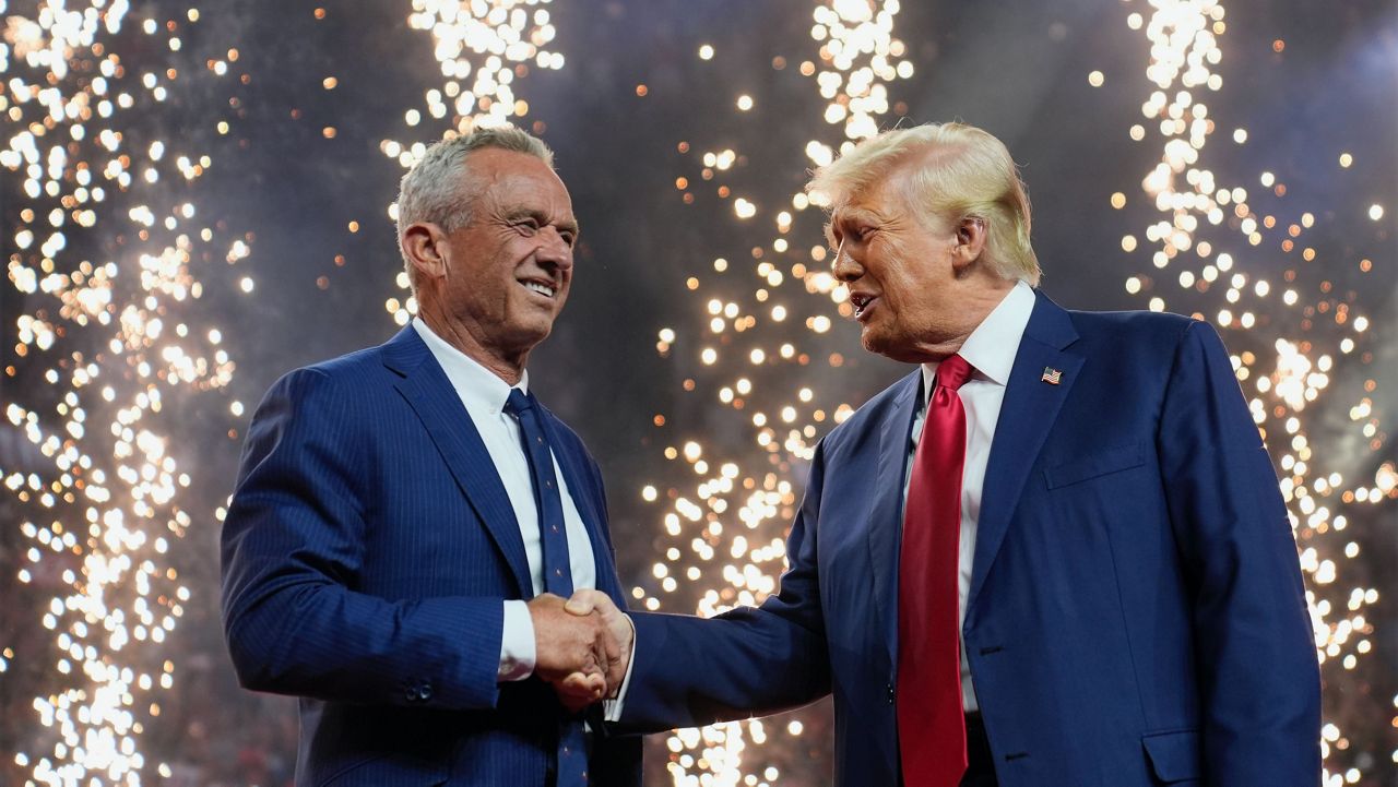 Republican presidential nominee former President Donald Trump shakes hands with Independent presidential candidate Robert F. Kennedy Jr. at a campaign rally at the Desert Diamond Arena, Friday, Aug. 23, 2024, in Glendale, Ariz. (AP Photo/Evan Vucci)