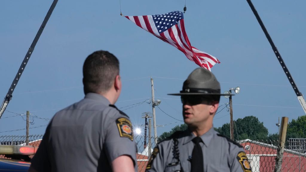 Police officers stand at a road leading to the site of the Trump rally, where access is closed, as investigations into the assassination attempt on former President Donald Trump continue, in Butler, Pa., July 14, 2024. (AP Photo/Sue Ogrocki, File)