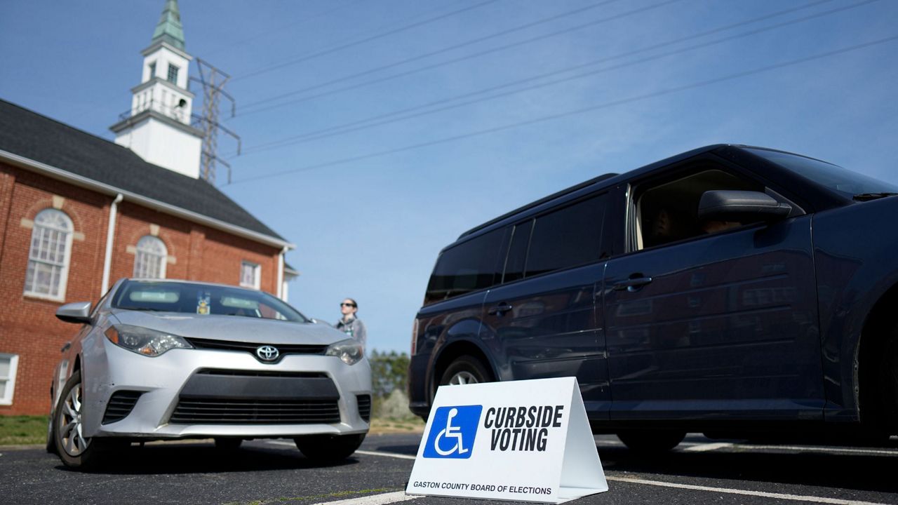 Super Tuesday election worker Brianna Feher talks to curbside voters Tuesday, March 5, 2024, in Mount Holly, N.C. (AP Photo/Chris Carlson)