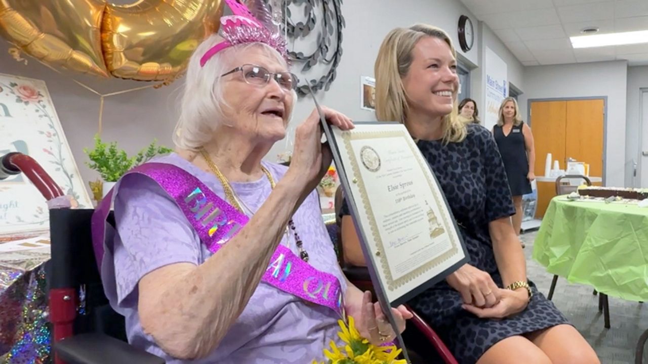 Elsie Sprous, left, displays her Illinois Senate Certificate of Recognition that was presented by State Sen. Erica Harriss, right. (Spectrum News/Elizabeth Barmeier)