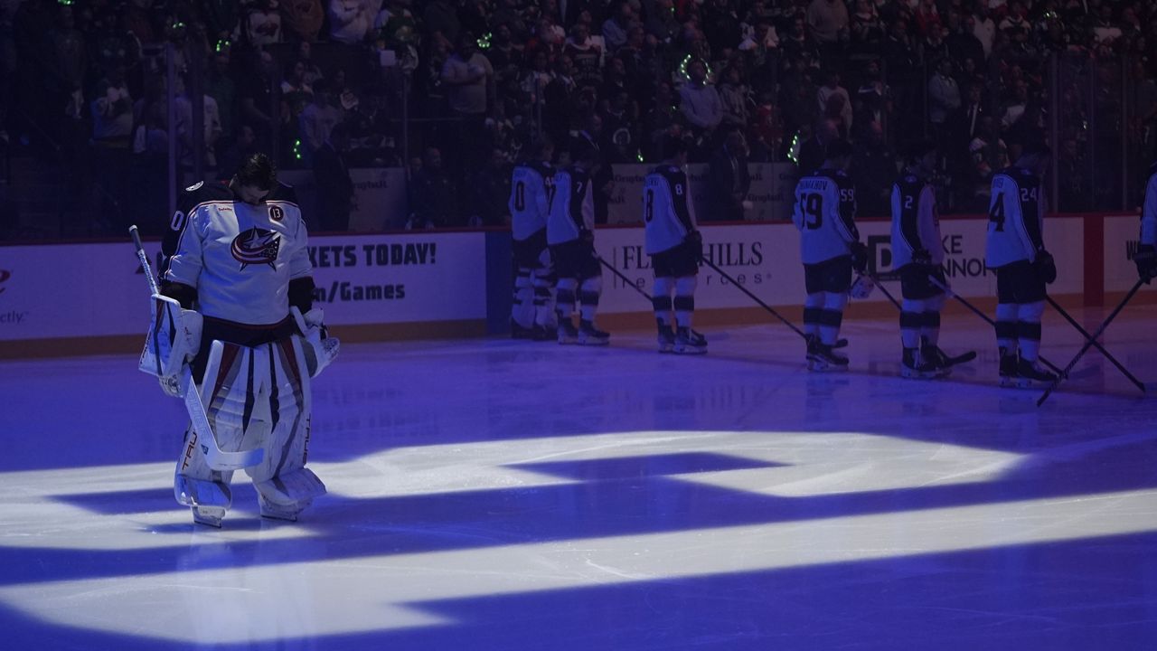 Columbus Blue Jackets goaltender Elvis Merzlikins (90) stands on a No. 13 on the ice honoring former Blue Jackets player Johnny Gaudreau and his brother Matthew Gaudreau who were killed by a driver in New Jersey in August, before an NHL hockey game against the Minnesota Wild, Thursday, Oct. 10, 2024, in St. Paul, Minn.