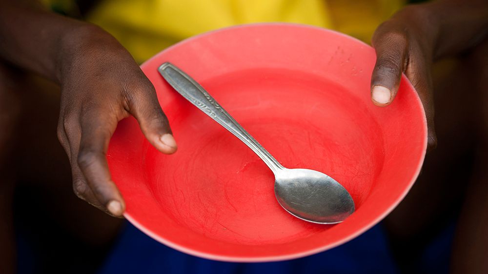 A person holds out an empty plate to be served. (Getty Images)