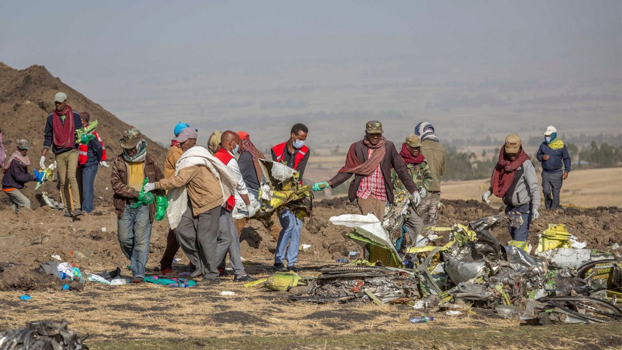 Debris is carried at the scene of an Ethiopian Airlines flight crash near Bishoftu, or Debre Zeit, south of Addis Ababa, Ethiopia, on March 11, 2019. A spokesman says Ethiopian Airlines has grounded all its Boeing 737 Max 8 aircraft as a safety precaution, following the crash of one of its planes in which 157 people were killed. (AP Photo/Mulugeta Ayene)