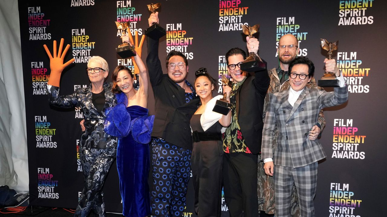 Jamie Lee Curtis, from left, wearing hot dog fingers based on a prop from the film "Everything Everywhere All at Once," Michelle Yeoh, Daniel Kwan, Stephanie Hsu, Jonathan Wang, Daniel Scheinert and Ke Huy Quan pose in the press room at the Film Independent Spirit Awards on Saturday, March 4, 2023, in Santa Monica, Calif. (Photo by Jordan Strauss/Invision/AP)
