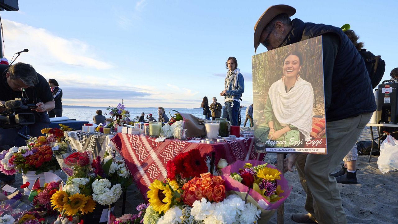 A photo is placed among flowers in memory of the death of the 26-year old Aysenur Ezgi Eygi at vigil on Alki Beach, killed recently in the occupied West Bank, Wednesday, Sept. 11, 2024, in Seattle. Eygi grew up in Seattle, attended Seattle Public Schools and graduated from the University of Washington. (AP Photo/John Froschauer)