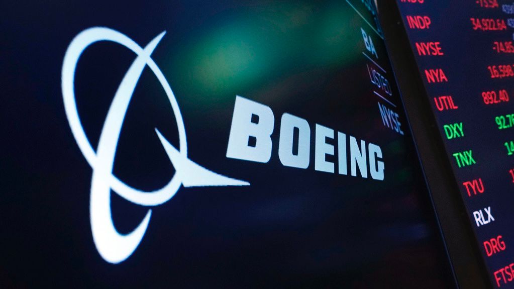The logo for Boeing appears on a screen above a trading post on the floor of the New York Stock Exchange, July 13, 2021. (AP Photo/Richard Drew)