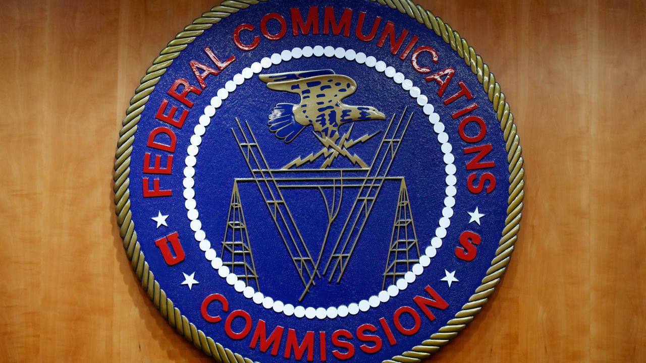 The seal of the Federal Communications Commission (FCC) is seen before an FCC meeting to vote on net neutrality, Dec. 14, 2017, in Washington. The Federal Communications Commission is outlawing robocalls that contain voices generated by artificial intelligence. The decision sends a clear message that exploiting the technology to scam people and mislead voters won’t be tolerated. (AP Photo/Jacquelyn Martin, File)