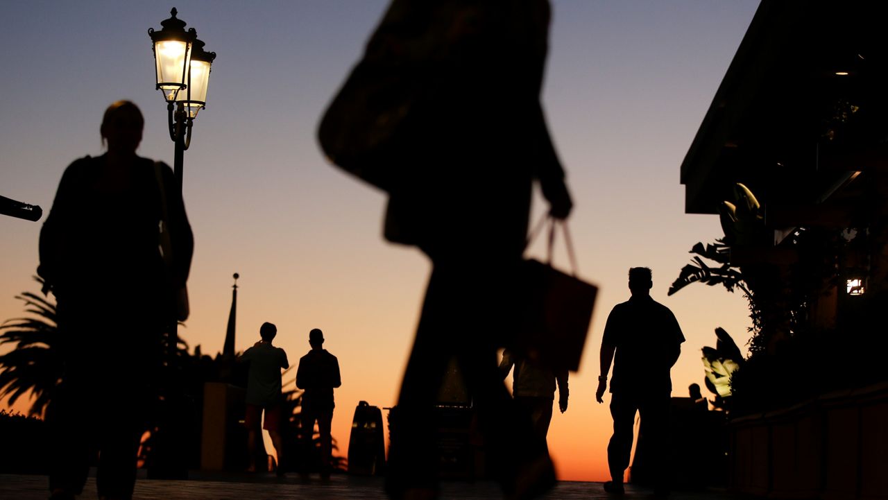 People walk through the Fashion Island shopping center in Newport Beach, Calif. (AP Photo/Chris Carlson)