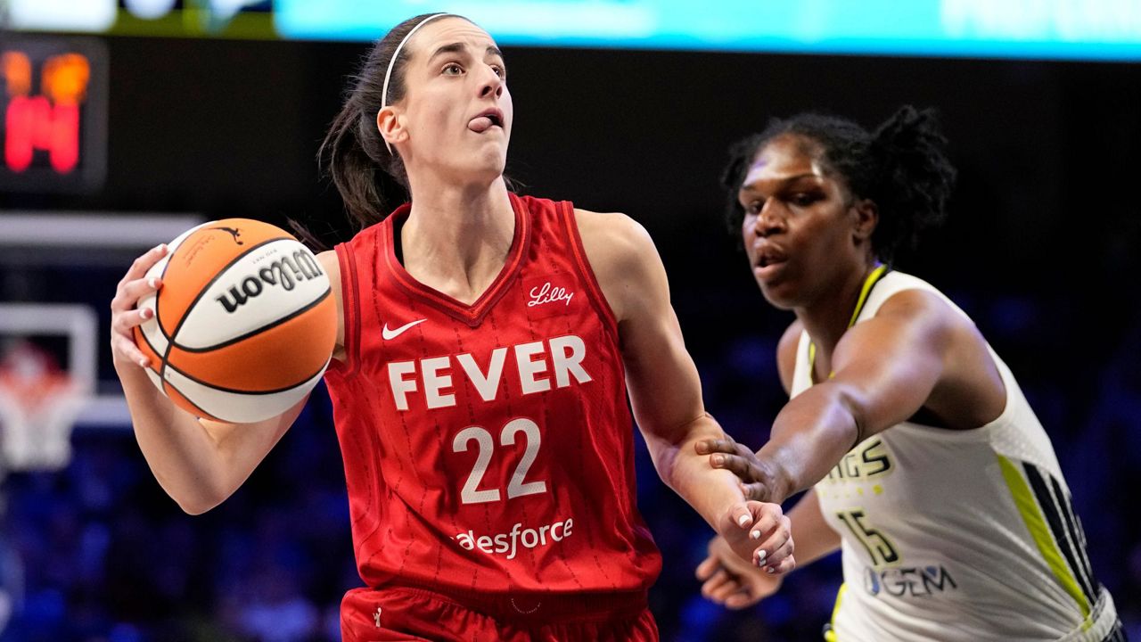 Indiana Fever's Caitlin Clark (22) drives to the basket past Dallas Wings' Teaira McCowan in the first half of a WNBA basketball game Wednesday, July 17, 2024, in Arlington, Texas. (AP Photo/Tony Gutierrez)