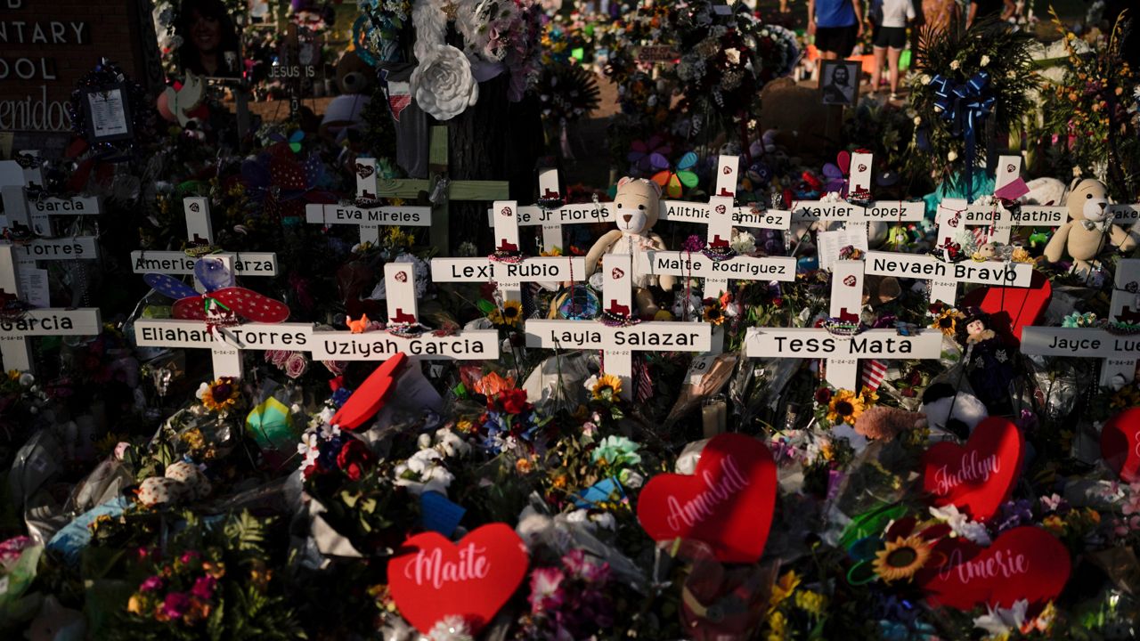 Flowers are piled around crosses with the names of the victims killed in a school shooting as people visit a memorial at Robb Elementary School to pay their respects May 31, 2022, in Uvalde, Texas. (AP Photo/Jae C. Hong, File)