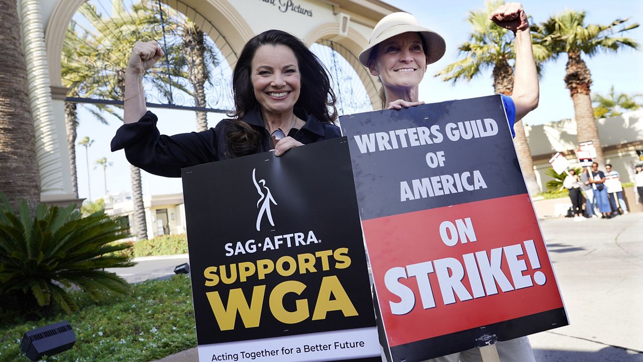 Fran Drescher, left, president of SAG-AFTRA, and Meredith Stiehm, president of Writers Guild of America West, pose together during a rally by striking writers outside Paramount Pictures studio, Monday, May 8, 2023, in Los Angeles. (AP Photo/Chris Pizzello)