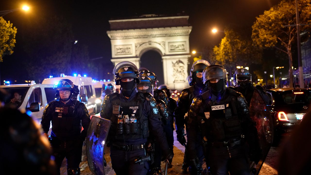 Police officers patrol in front of the Arc de Triomphe on the Champs Elysees in Paris, Saturday, July 1, 2023. President Emmanuel Macron on Saturday scrapped an official trip to Germany after a fourth straight night of rioting and looting across France in defiance of a massive police deployment. Hundreds turned out for the burial of the 17-year-old whose killing by police triggered the unrest. (AP Photo/Christophe Ena)