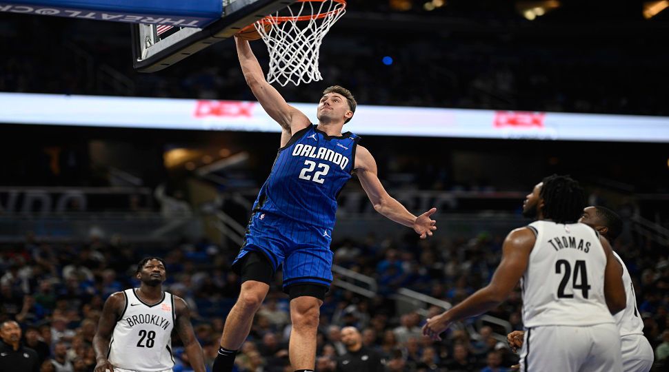 Orlando Magic forward Franz Wagner (22) dunks between Brooklyn Nets forward Dorian Finney-Smith (28) and guard Cam Thomas (24) during the second half of an NBA basketball game, Friday, Oct. 25, 2024, in Orlando, Fla. (AP Photo/Phelan M. Ebenhack)