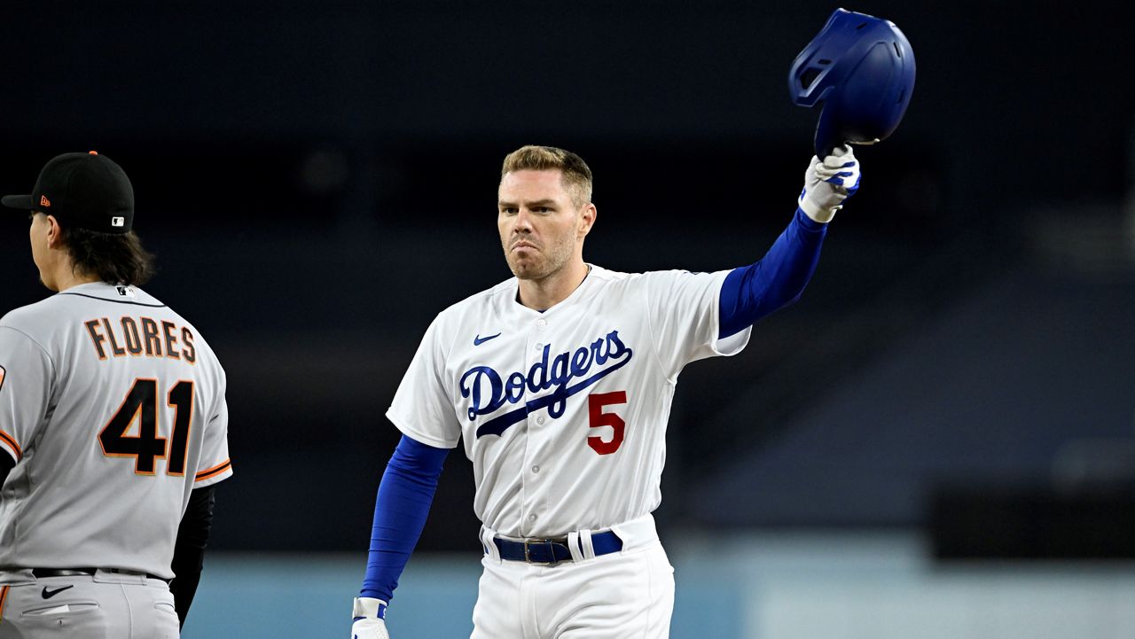 Los Angeles Dodgers' Freddie Freeman, right, acknowledges the fans after hitting his 200th hit for the season during the first inning of a baseball game against the San Francisco Giants in Los Angeles, Friday, Sept. 22, 2023. Giants first baseman Wilmer Flores, left, looks on. (AP Photo/Alex Gallardo)