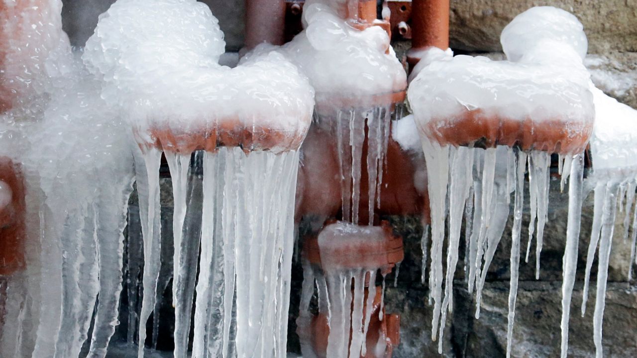 Ice coats leaking pipes along an alley in Cleveland, Monday, March 2, 2015. (AP Photo/Mark Duncan)