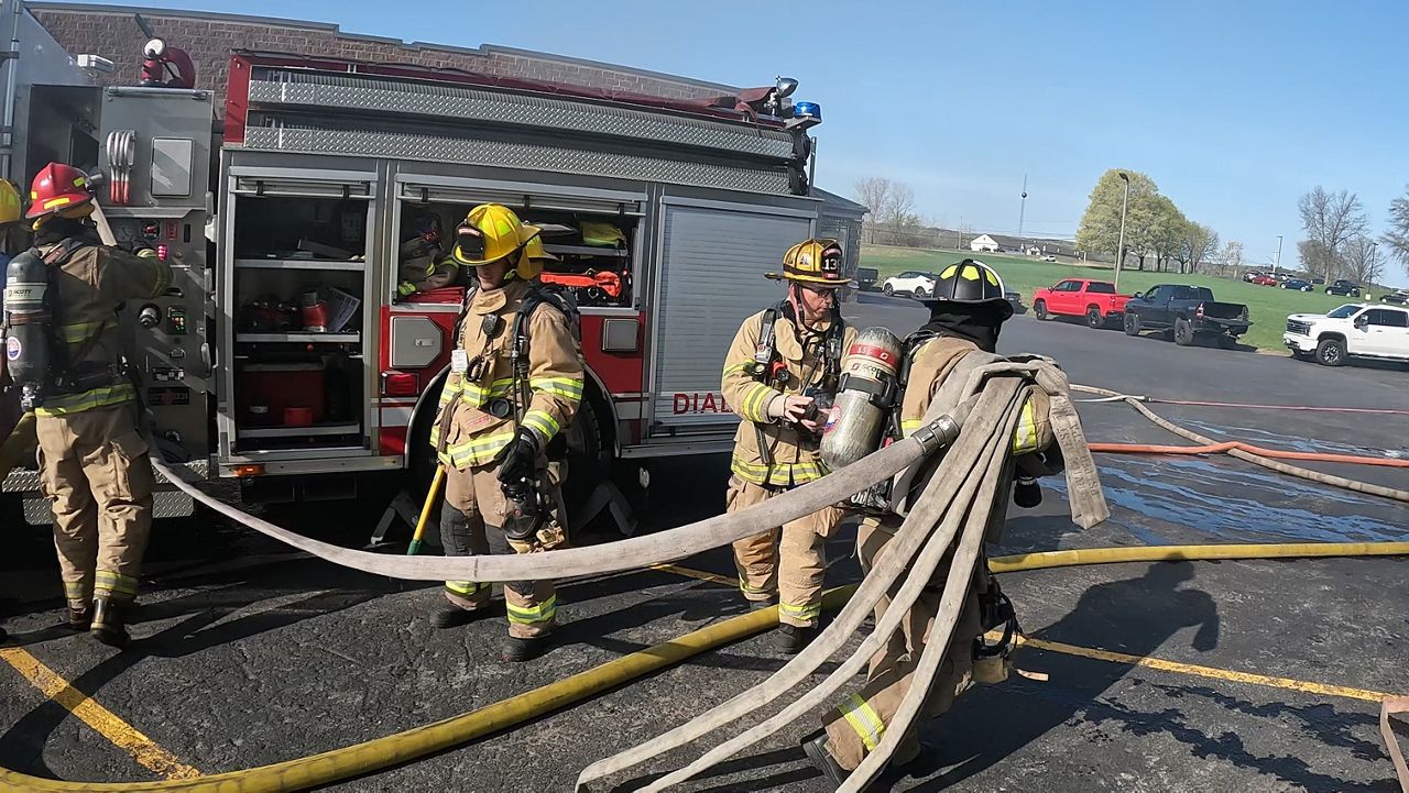 Firefighters unload hoses