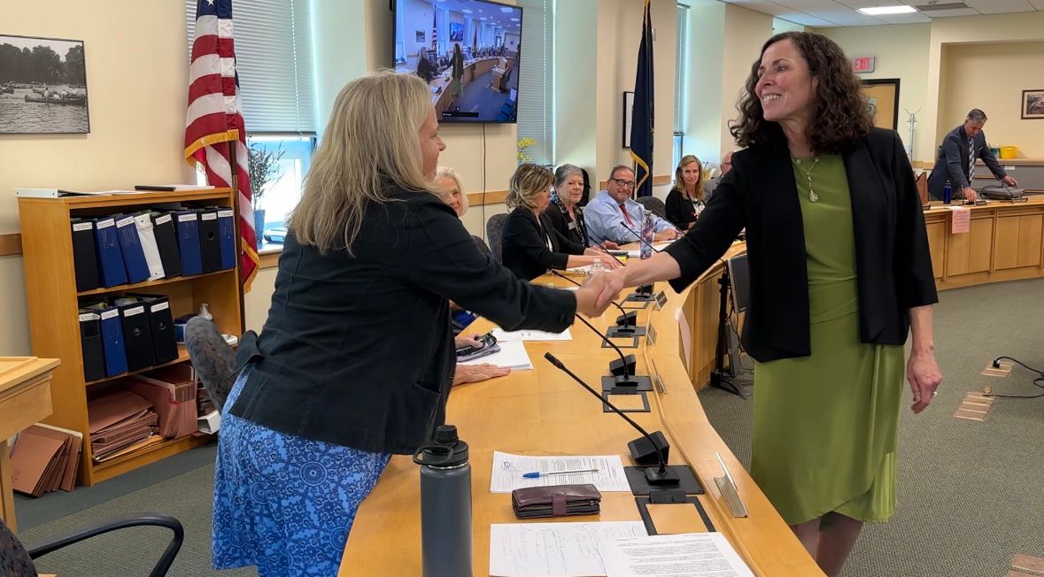 Rep. Anne Graham (D-North Yarmouth), left, congratulates Sara Gagne-Holmes, right, after the Health and Human Services Committee voted 10-2 in favor of Gagne-Holmes' nomination to lead the Maine Department of Health and Human Services. (Spectrum News/Susan Cover)