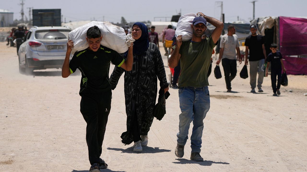 Palestinians carry food and humanitarian aid delivered by the U.S.-backed Gaza Humanitarian Foundation, after receiving the supplies in Rafah, as they arrive in Khan Younis, southern Gaza Strip, on Wednesday, May 28, 2025. (AP Photo/Abdel Kareem Hana)