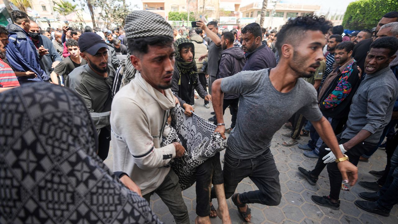 Palestinians carry a wounded person following an Israeli airstrike near the Al Aqsa hospital in Deir al Balah, Gaza Strip, Sunday, March 31, 2024. (AP Photo/Abdel Kareem Hana)