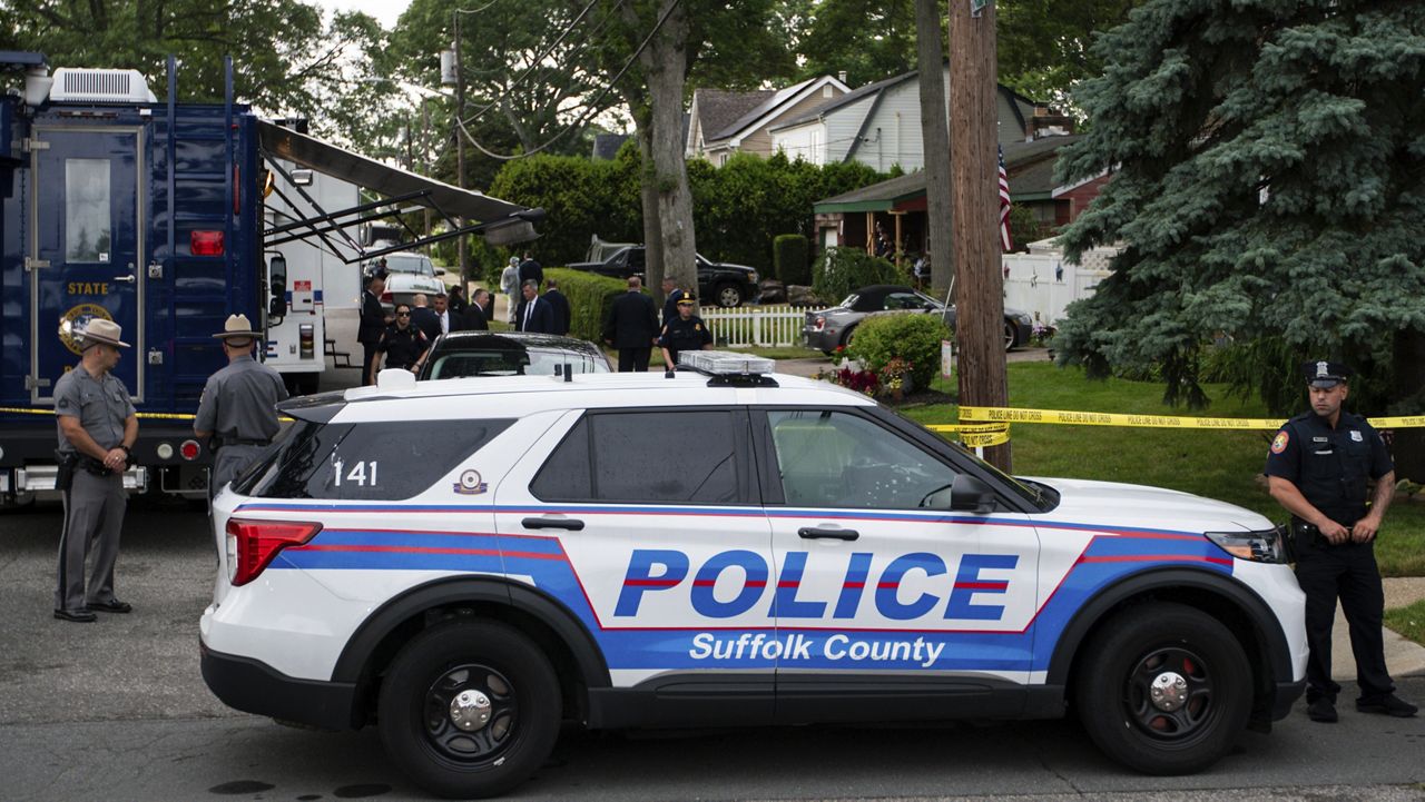 Police officers stand guard near the house where a suspect has been taken into custody on New York's Long Island in connection with a long-unsolved string of killings, known as the Gilgo Beach murders, Friday, July 14, 2023, in Massapequa Park, N.Y. (AP Photo/Eduardo Munoz Alvarez)