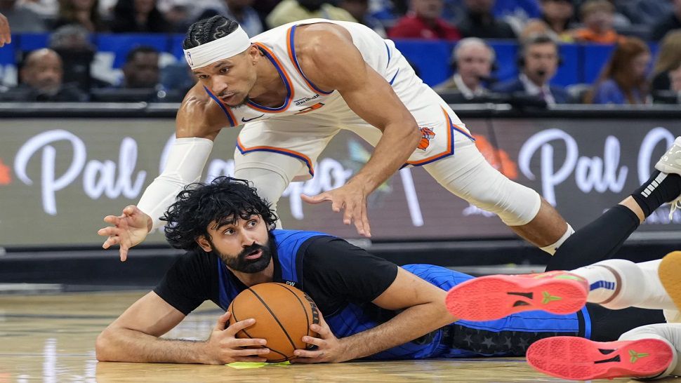 Orlando center Goga Bitadze beats New York guard Josh Hart to a loose ball during Friday night's game.