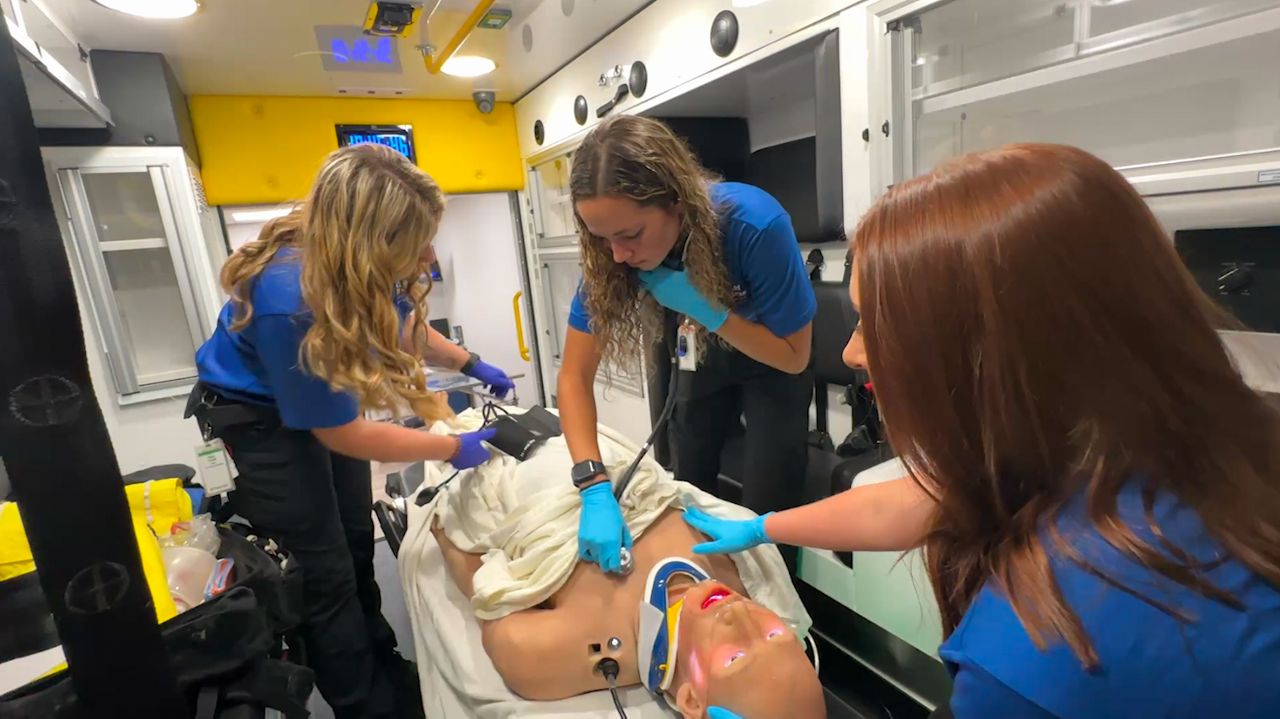 A group of Gold Cross paramedic students assess a simulated patient in an ambulance at the new Menasha training center.
