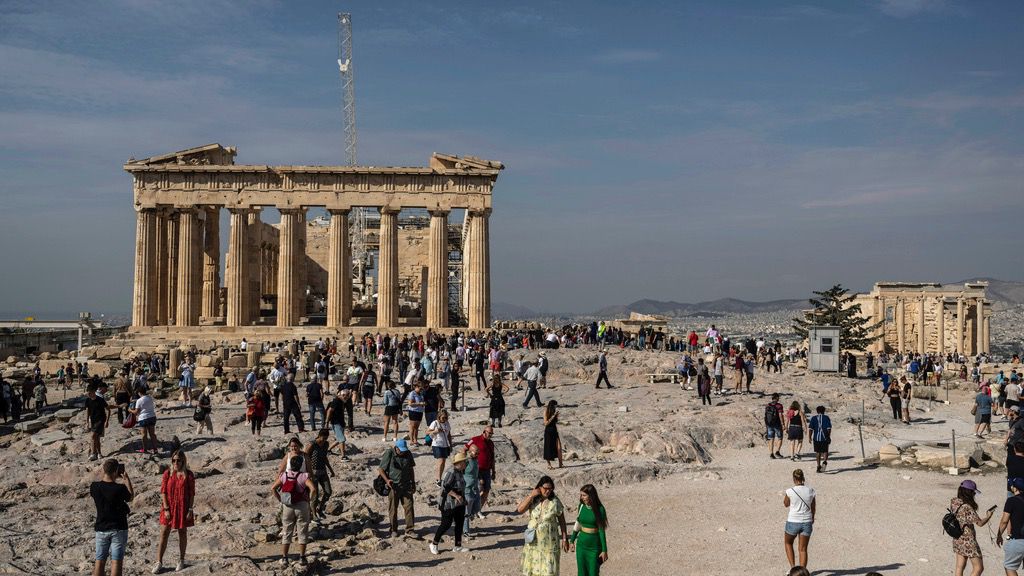 Tourists visit the Acropolis hill with the 2,500-year-old Parthenon temple on the left, and the ancient Erechtheion temple on the right, in Athens, Greece, on Oct. 11, 2022. (AP Photo/Petros Giannakouris, File)