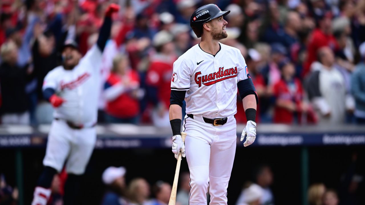 Cleveland Guardians' Lane Thomas, right, watches his grand slam in the fifth inning during Game 5 of baseball's American League Division Series against the Detroit Tigers, Saturday, Oct. 12, 2024, in Cleveland.