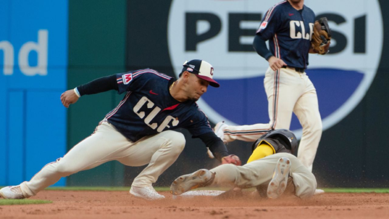 Cleveland Guardians' Andres Gimenez, left, tags San Diego Padres' Kyle Higashioka out at second base on a steal attempt during the fifth inning of a baseball game in Cleveland, Friday, July 19, 2024. 