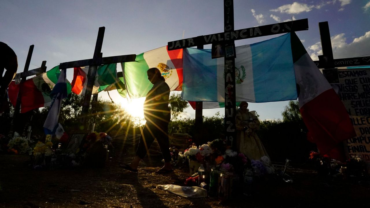 Mourners visit a make-shift memorial to honor the victims and survivors of a human smuggling tragedy in which dozens of migrants were found dead or dying in a tractor-trailer a week prior, July 6, 2022, in San Antonio. (AP Photo/Eric Gay, File)